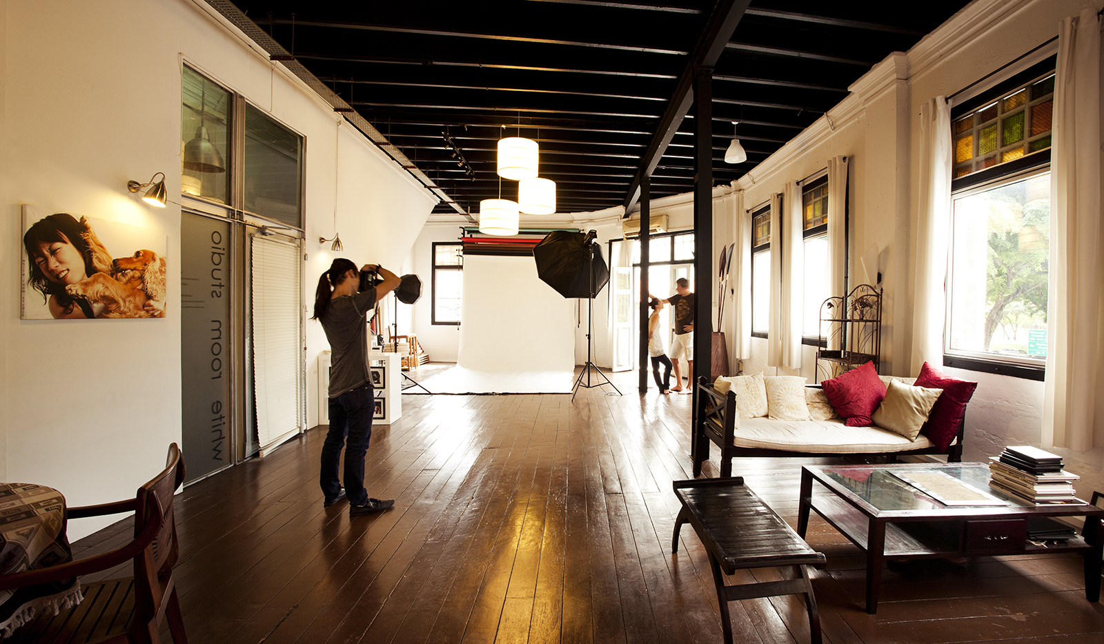 Interior of a photography studio with models, photographers, and equipment during a photoshoot. White Room Studio Singapore