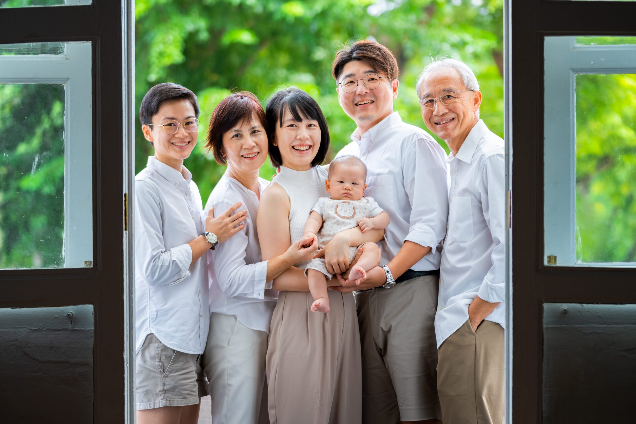 Multi-generation family with parents, grandparents and their kids in a photography studio setting during a family photoshoot in Singapore, White Room Studio. Credit: White Room Studio Pte Ltd