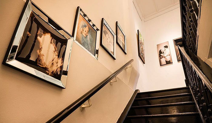 Wooden stairwell lined with portraits at White Room Studio Singapore