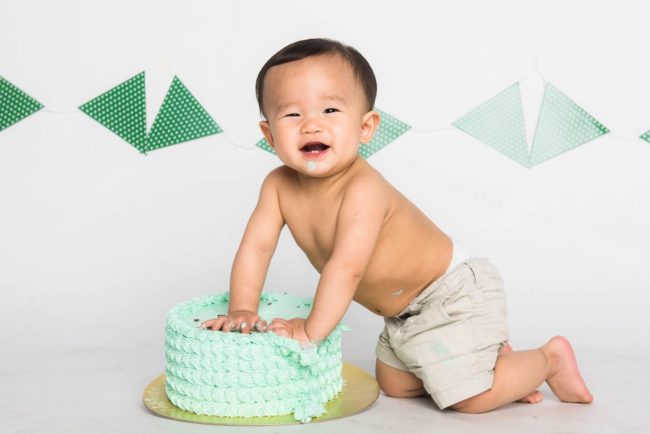 Baby Cake Smash Photography Singapore toddler young boy smiling and playing with mint cream cake