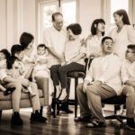 Generation photoshoot of large family of grandparents, parents, children and grandchildren sepia tone indoor portrait photography
