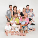 Family multi generation photoshoot of a large Caucasian family with grandparents, parents and grandchildren with white background