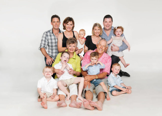 Family multi generation photoshoot of a large Caucasian family with grandparents, parents and grandchildren with white background