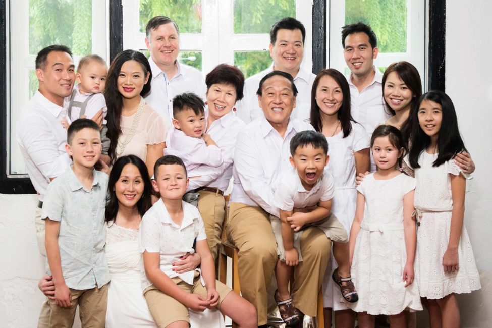Generation family photoshoot package of large family smiling with grandparents, parents and grandchildren dressed in white and tan colours