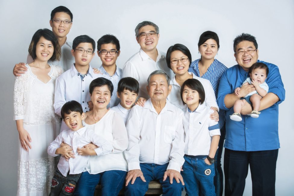 Multi generation photoshoot session with grandparents, parents and young children with white background