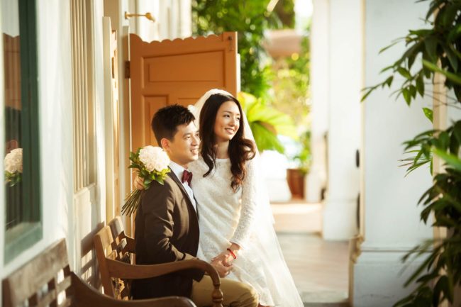 Bridal Photoshoot Singapore bride and groom sitting down on bench both smiling outdoors sunset photography