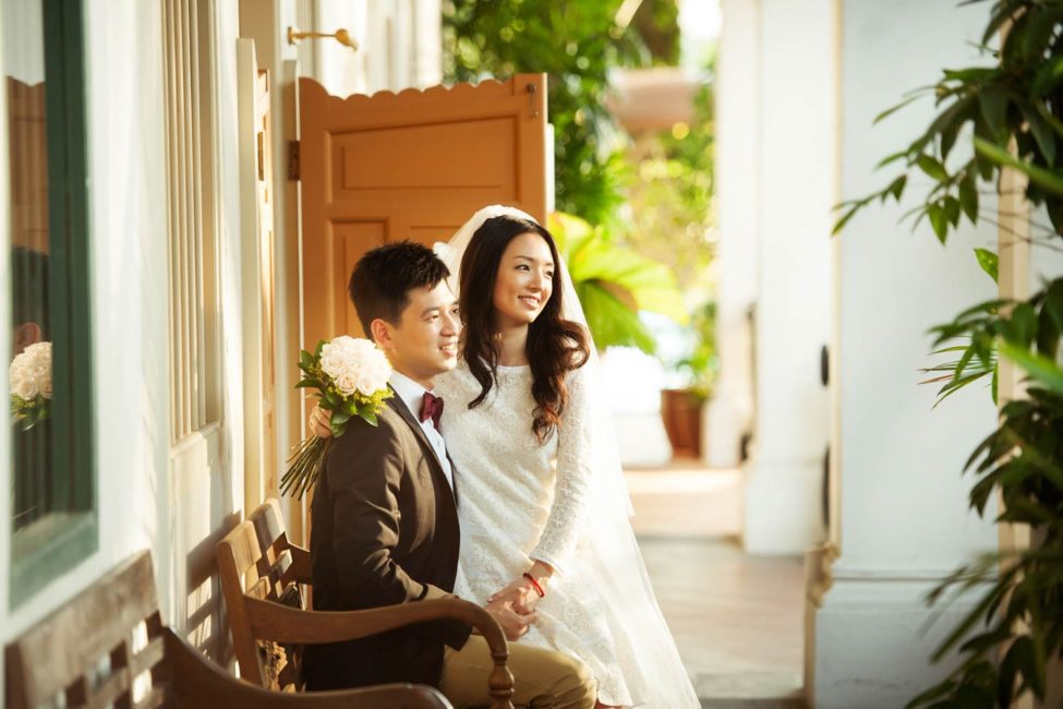 Bridal Photoshoot Singapore bride and groom sitting down on bench both smiling outdoors sunset photography