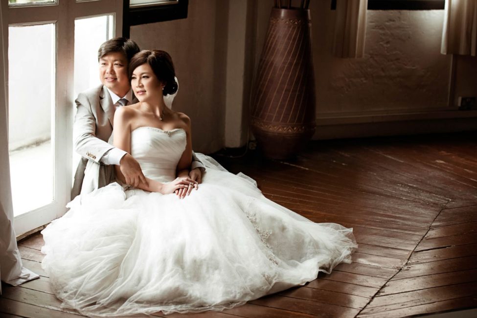 Bridal Photoshoot Singapore bride and groom sitting on floor and looking out the window indoor natural light photography