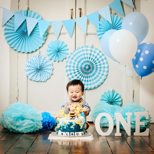 Cake Smash Photography Singapore baby boy toddler celebrating first birthday with special cake and blue party decorations
