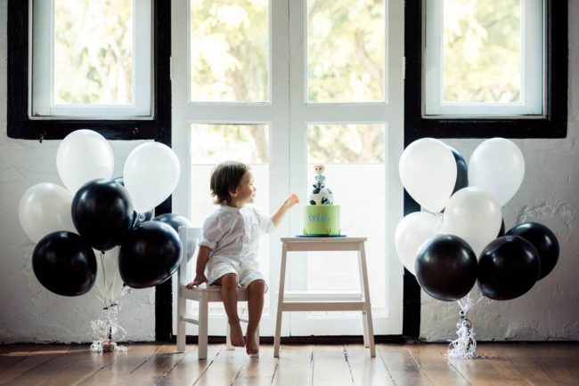 Cake Smash Photography Singapore toddler first year indoor photoshoot with soccer themed cake and black and white balloons