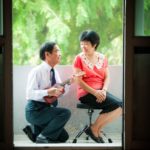 Couple Photography Singapore elderly couple man playing ukulele for woman sitting down with nature landscape background