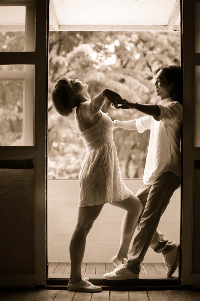 Couple Photography Singapore man and woman dance posing at door frame indoor photoshoot sepia tone portrait