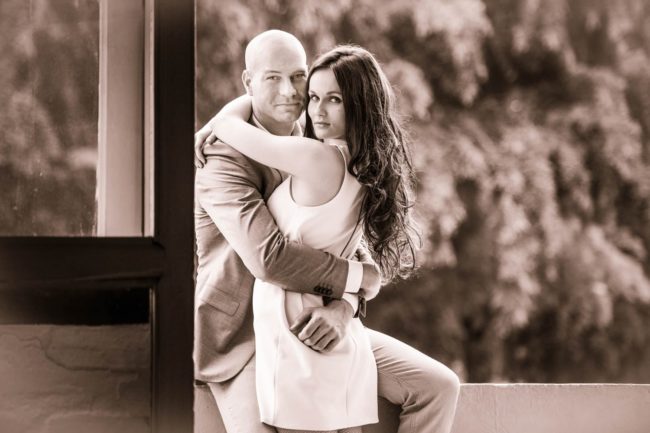 Couple Photoshoot Singapore man in suit and woman in white dress hugging black and white portrait