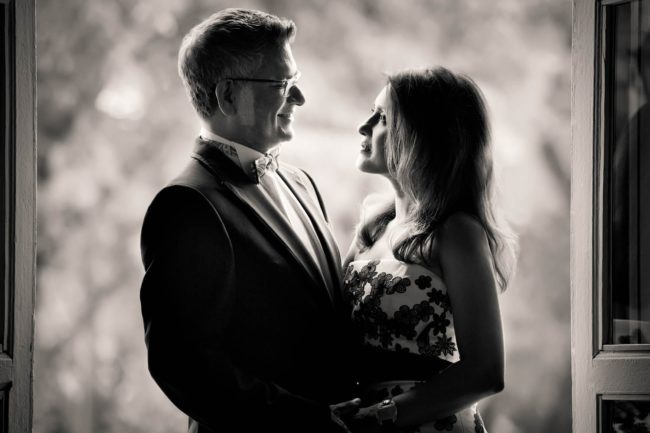 Couple Photoshoot Singapore man and woman holding and looking at each other at door frame black and white portrait