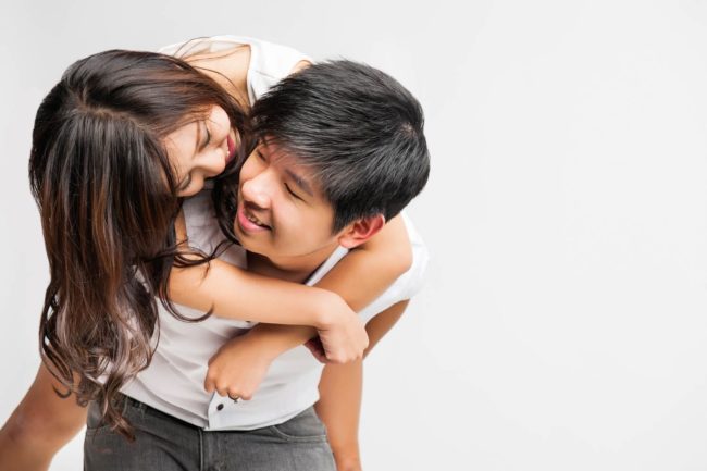 Couple Photoshoot Singapore man carrying woman by piggyback both smiling