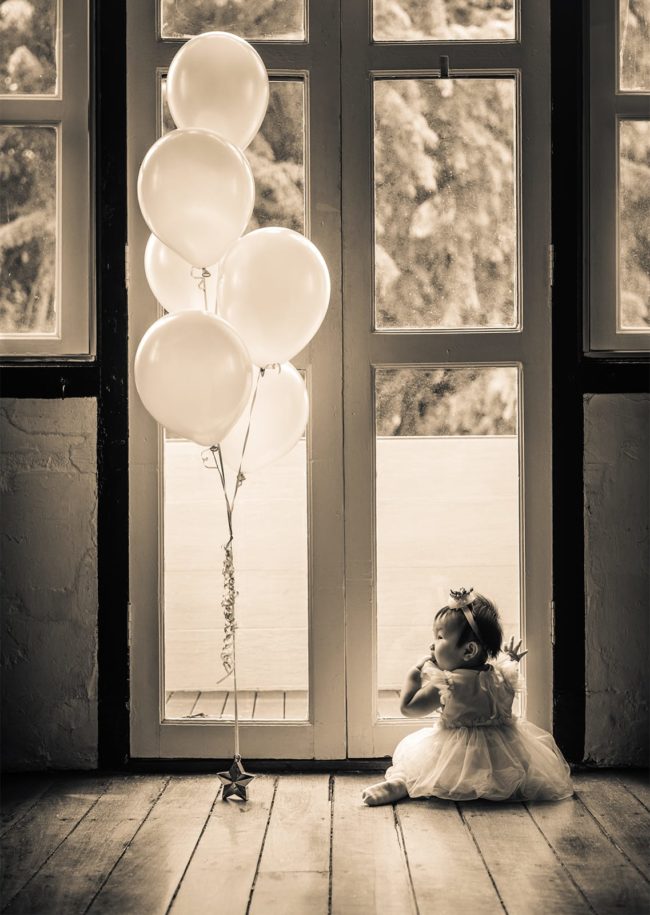 First Year Photography Singapore toddler young girl in dress at photoshoot with balloons black and white photography