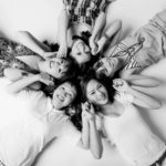 Glamour Photography Singapore 5 smiling friends photoshoot lying on the floor and holding hands black and white portrait photography