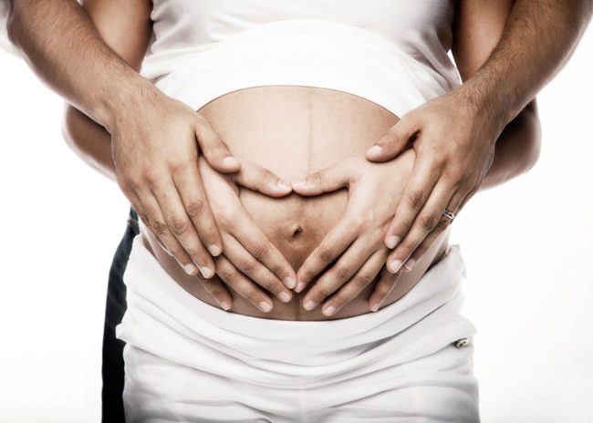 Maternity Photoshoot Singapore husband and wife layering hands making a heart shape on pregnant belly