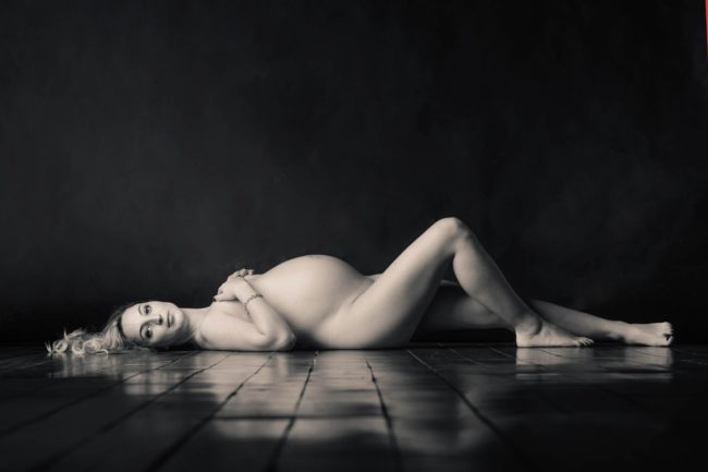 Maternity Photoshoot Singapore intimate boudoir semi-nude pregnant mother lying on wooden floor black and white portrait photography