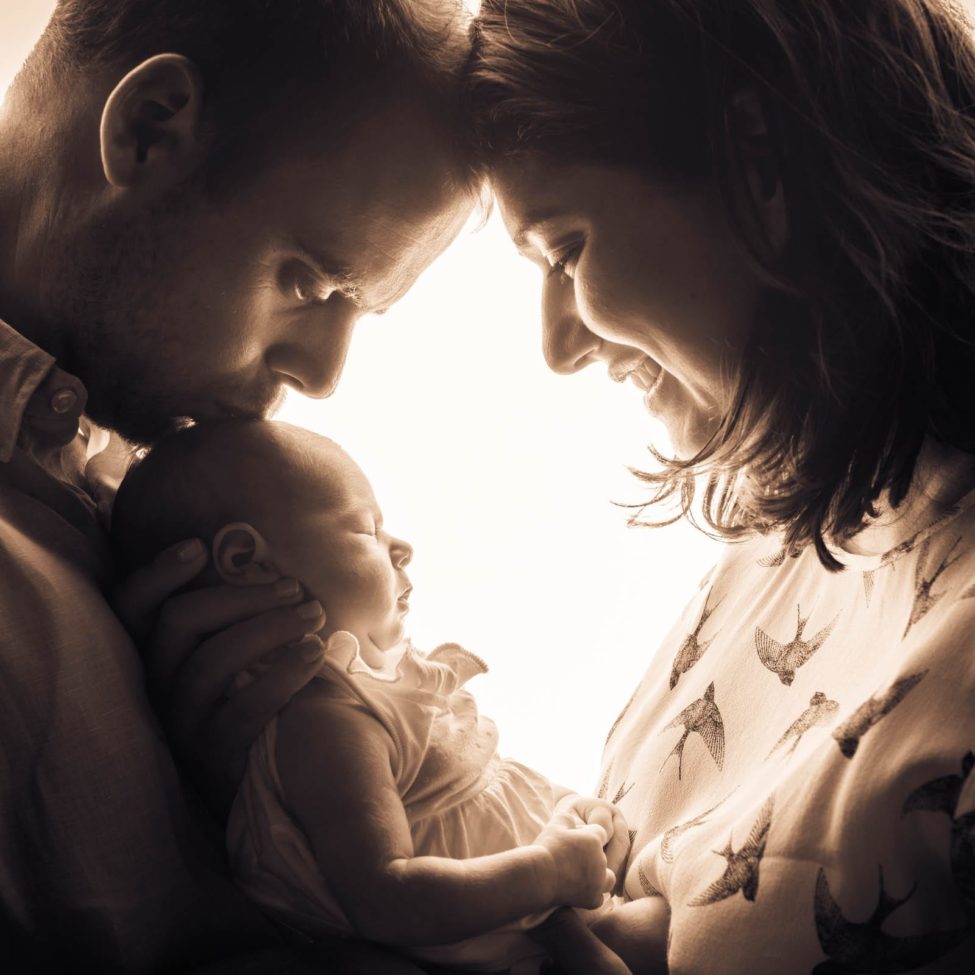 Newborn Photography Singapore father and mother holding baby sepia tone photography