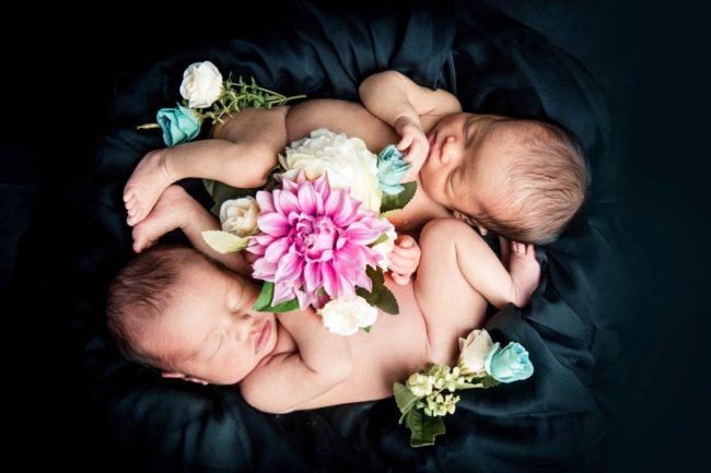 Newborn Photoshoot Singapore 2 babies twins curled up with flowers on black cloth