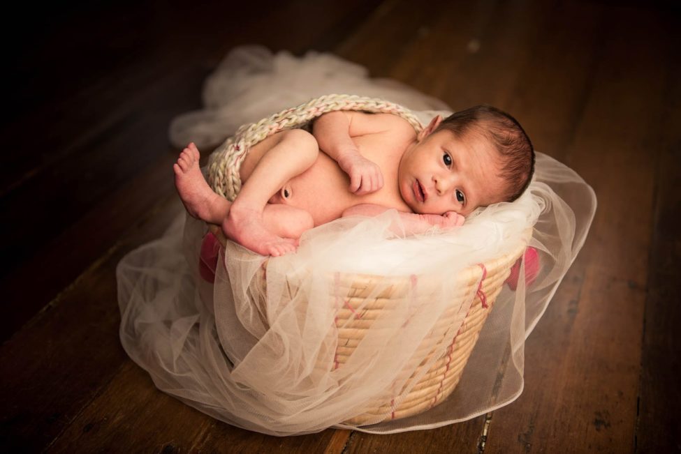 Newborn Photoshoot Singapore baby curled up in white mesh cloth basket