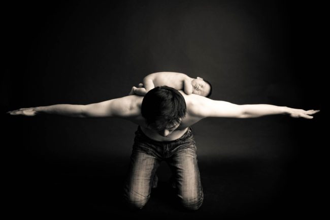 Newborn Photoshoot Singapore baby lying on fathers bare back black and white portrait photography
