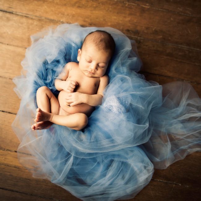 Newborn Photoshoot Singapore baby sleeping on blue cloths in natural light