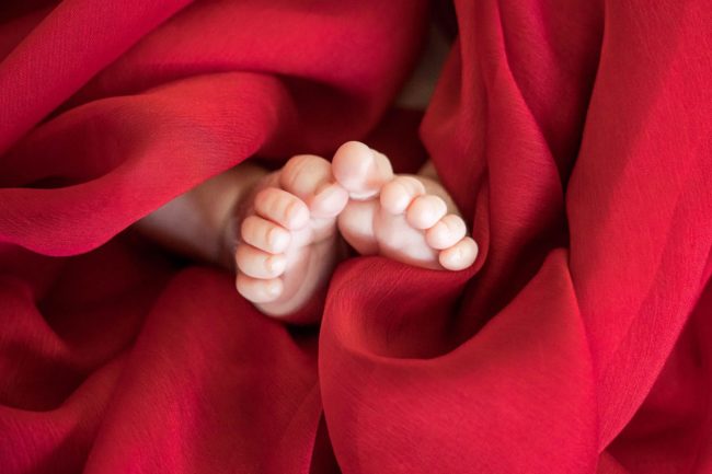 Newborn Shoot Singapore baby feet and toes with red cloths zoomed in