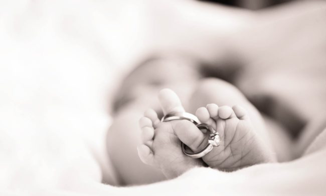 Newborn Shoot Singapore father and mother wedding rings on baby toes black and white photography