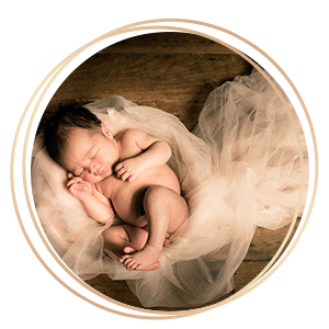 Newborn Baby Photography baby curled up resting on white mesh cloths