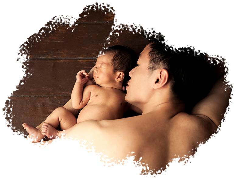 Newborn Shoot Singapore father cradling and facing sleeping baby on wooden floors