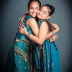 Family kids photography two girl children dressed in cultural Indian dressing blue saris hugging and smiling