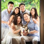 Family photoshoot studio photography of family of six huddled together with pet dog corgi