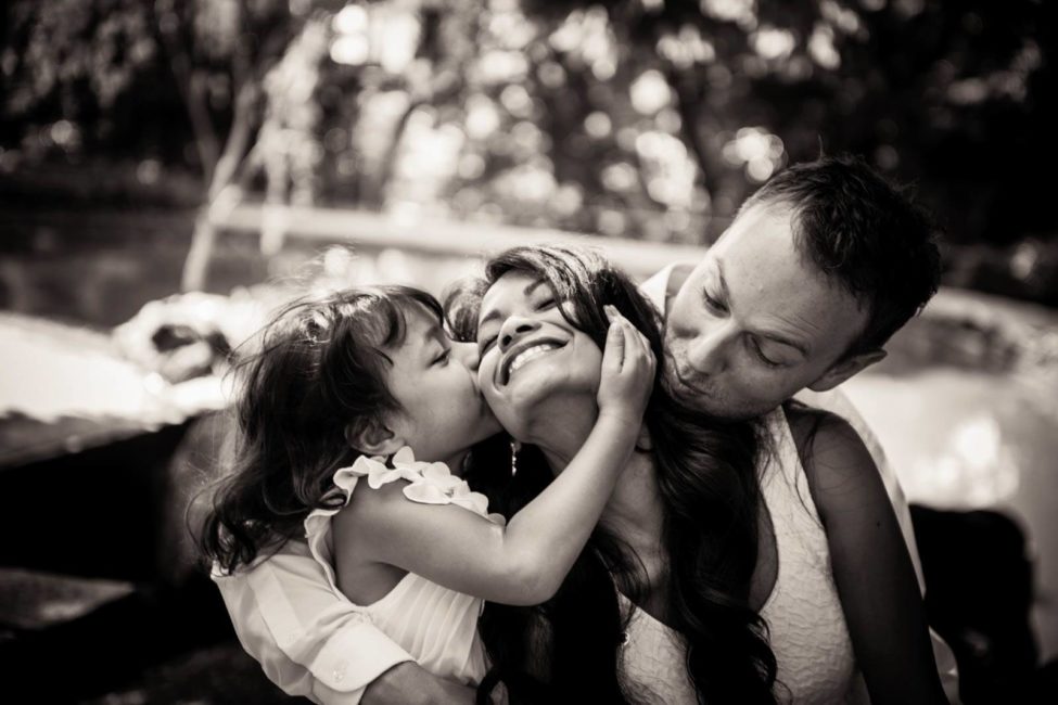 Family photoshoot package outdoor photography of father and young child kissing mother black and white portrait