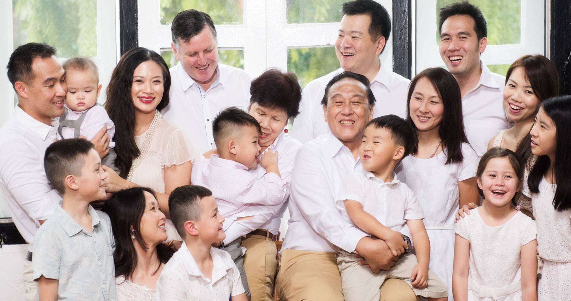 Professional Family & Multi Generation Photoshoot in Photography Studio, Singapore Multi generation photoshoot of large family dressed in white and smiling for candid photo