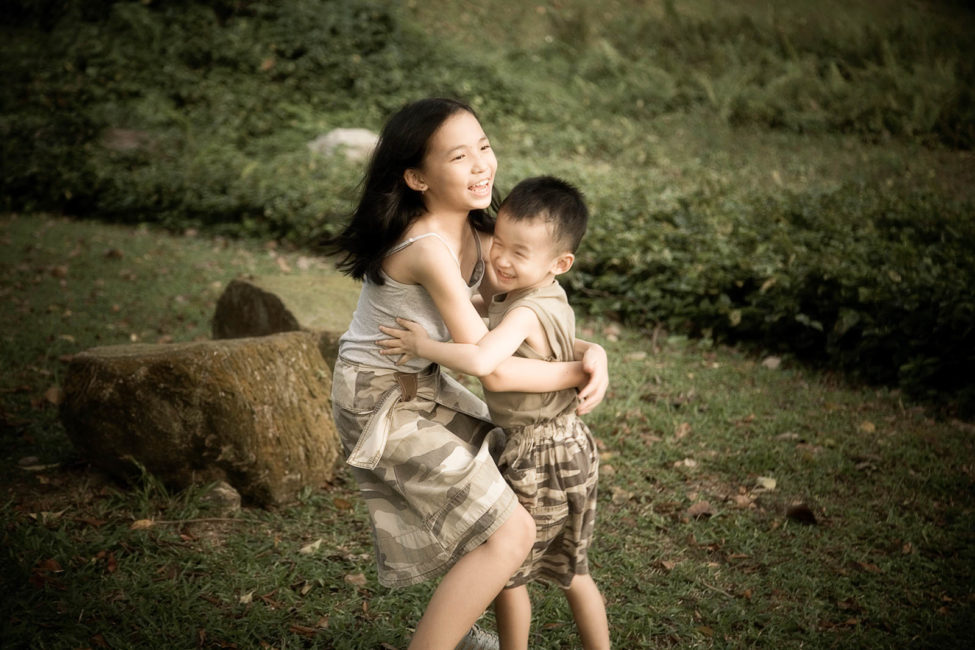 Children Outdoor Photoshoot Singapore sister and brother hugging at a park