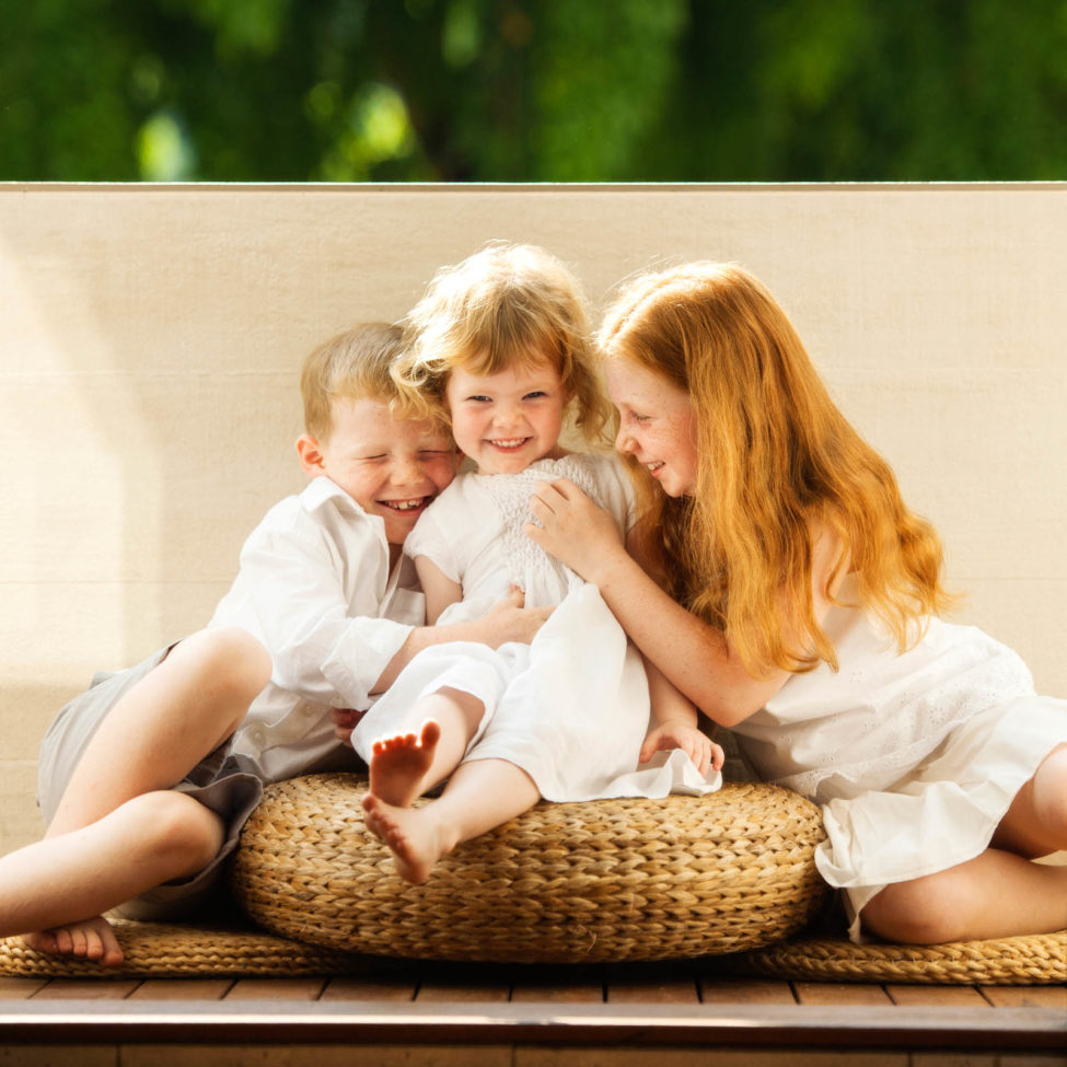 Children Photography Singapore 3 young siblings photoshoot sitting on rattan mats and seats