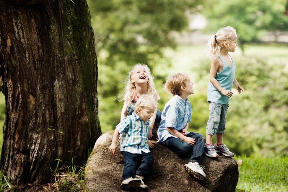 Children Photography Singapore Outdoor 4 happy children sitting on a boulder candid photoshoot