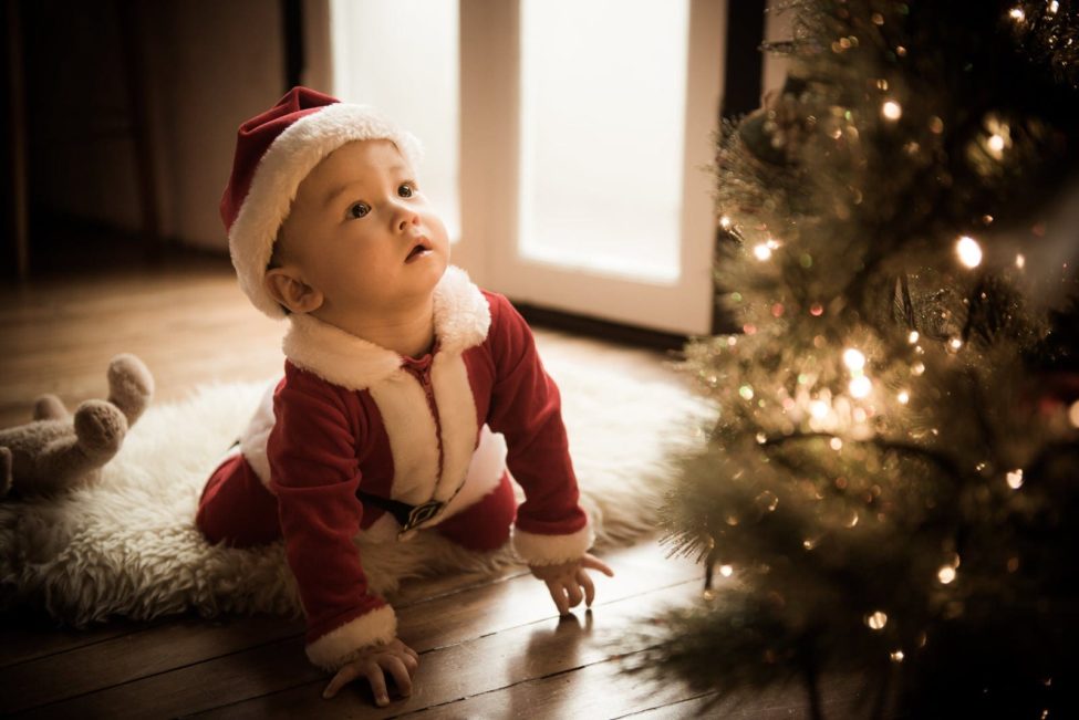 Children Photography Singapore young boy toddler in Santa Claus costume looking up at Christmas tree