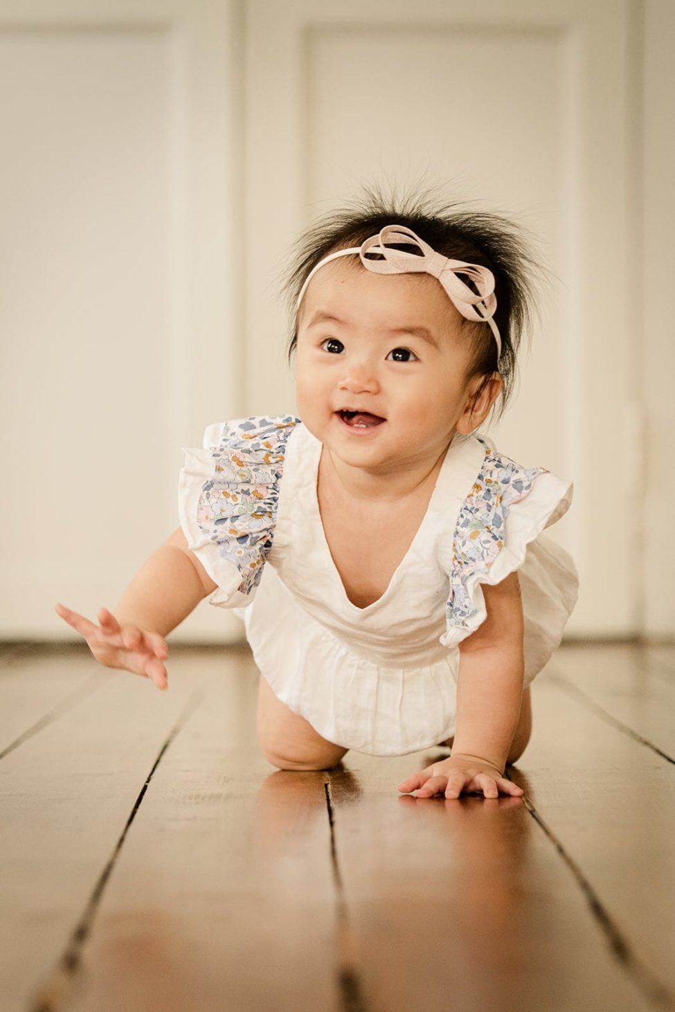 Children Photoshoot Natural smiling toddler crawling with pink bow and white dress