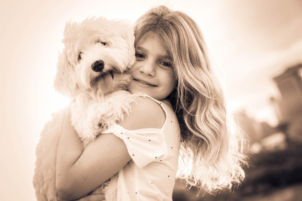 Children Photoshoot young girl smiling while carrying pet dog sepia tone portrait photography