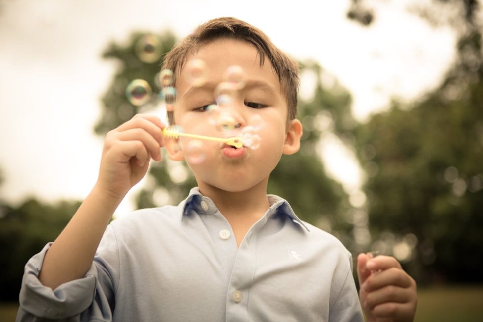 Children Singapore Photoshoot Outdoor young boy in dress shirt blowing bubbles at a park