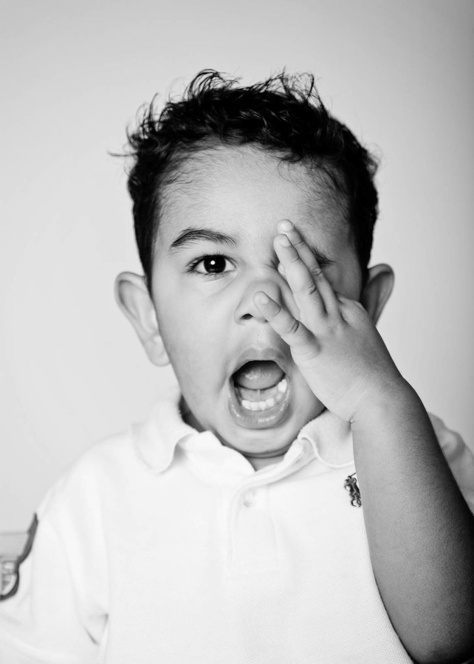 Kids Portrait Singapore Photo Studio toddler boy rubbing eye with mouth open black and white photography