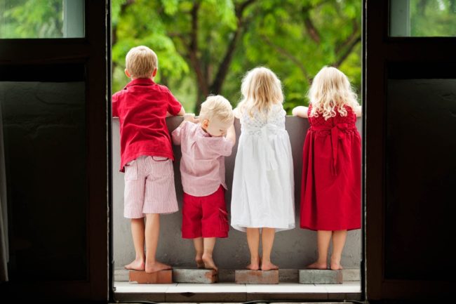 Kids Singapore Photoshoot back view of 4 children in red clothing looking out at a nature landscape