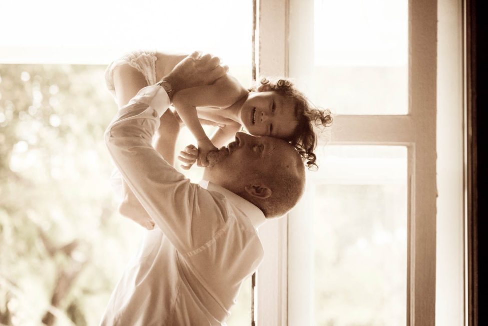 Kids Singapore Photoshoot father carrying smiling toddler above head sepia tone photography
