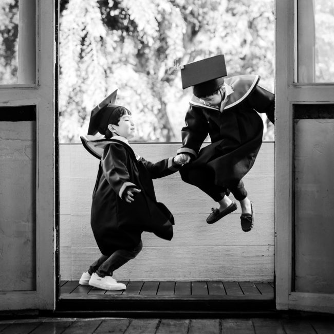 Boys jumping during a kindergarten graduation photoshoot in natural light at White Room Studio