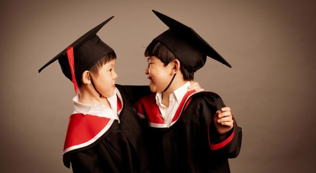 Two kids dressed in K2 graduation and cap during K2 Graduation photoshoot in Singapore, White Room Studio. Credit: White Room Studio Pte Ltd