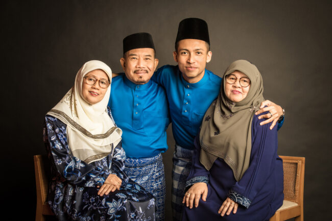 Family with parents and their children wearing Hari Raya baju in a photography studio setting during a family Hari Raya photoshoot in Singapore, White Room Studio. Credit: White Room Studio Pte Ltd