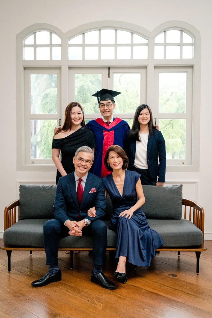 A family of five against a white wall and windows